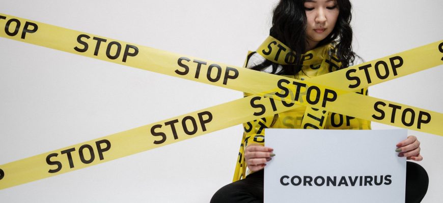 Woman sitting bonded by stop sign about coronavirus